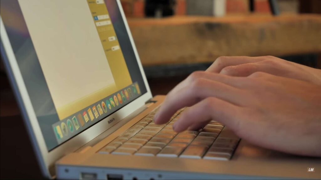 Close up of man typing on Apple laptop