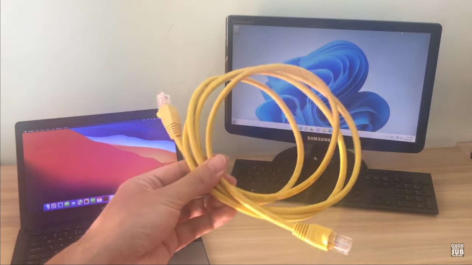 Man holding a cable to to connect macOS and Windows 11 together