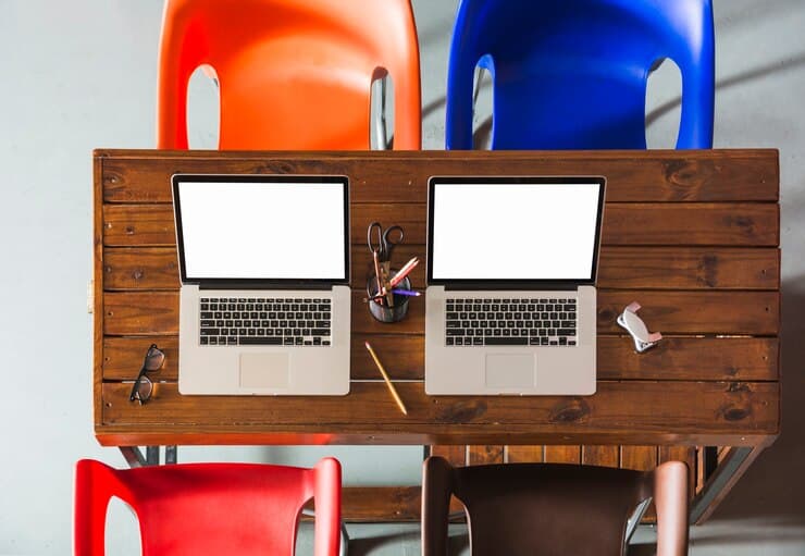 Two Open Laptops on the Wooden Table